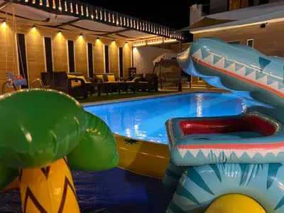 a swimming pool with a inflatable shark ride at Private Pool - Relax Chalet Deadsea in Amman