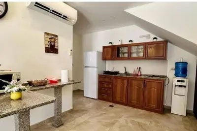 a kitchen with wooden cabinets and a white refrigerator at Private Pool - Relax Chalet Deadsea in Amman