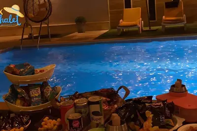 a pile of food next to a swimming pool at Private Pool - Relax Chalet Deadsea in Amman
