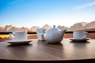 two tea cups and a teapot sitting on a table at Mars Land Luxury Camp in Wadi Rum