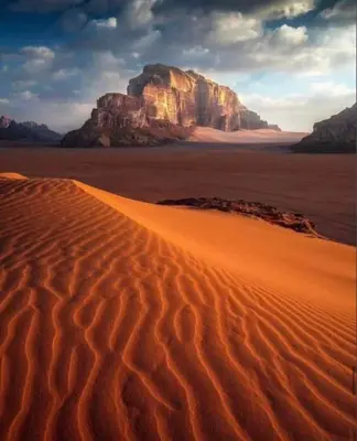 a desert with a mountain in the background at Bedouin cave wadi rum campsite in Wadi Rum