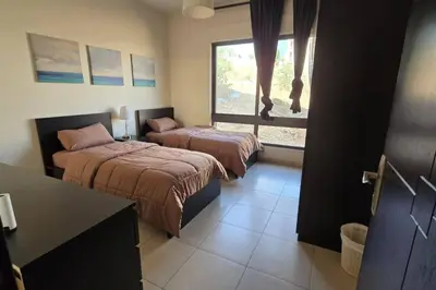 a bedroom with two beds and a window at Apartment the most upscale neighborhoods of Amman in Amman
