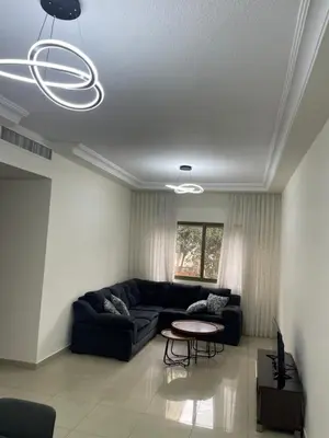 a living room with a couch and a table at Charming modern 2BD in Abdoun in Amman