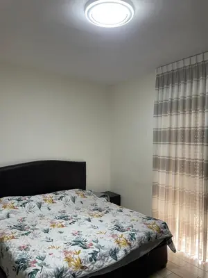 a bedroom with a bed with a floral comforter at Charming modern 2BD in Abdoun in Amman