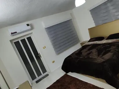 a bedroom with a bed and a window at شقة مفروشة مجهزة بكل الخدمات in Irbid