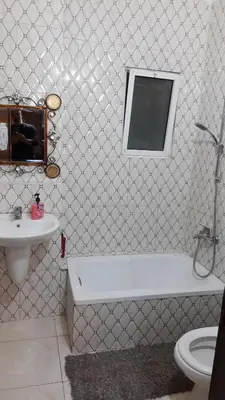 a bathroom with a tub and a sink and a toilet at شقة مفروشة مجهزة بكل الخدمات in Irbid