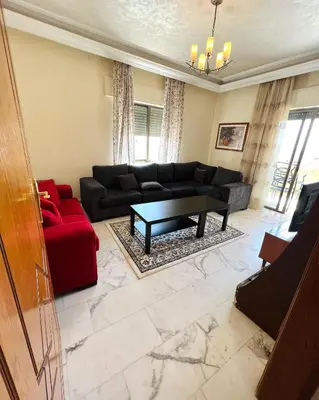a living room with a couch and a table at Furnished Apartment for Rent in Abdoun 200sqm in Amman