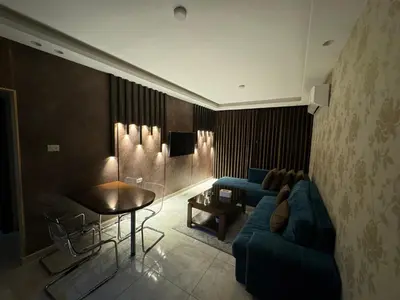 a living room with a blue couch and a table at Cozy apt Grt location for long and short stay in Amman