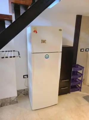a white refrigerator in a room with a staircase at Loft Apartment Jabal Amman B in Amman