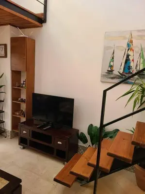 a living room with a flat screen tv and a table at Loft Apartment Jabal Amman B in Amman