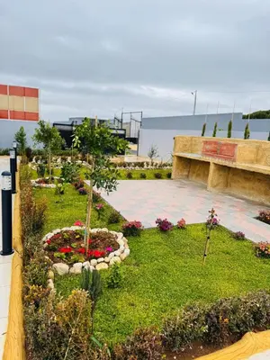 a garden with a park with flowers and a bench at منتجع الحور in Ajloun