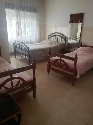 a bedroom with three beds and a mirror in it at Alotaibi bulding in Amman