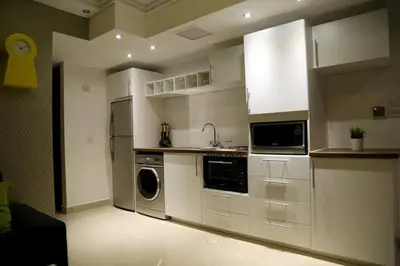 a kitchen with white cabinets and a washer and dryer at Apartment in Amman with wow furniture in Amman