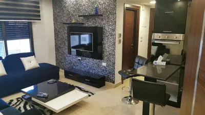 a living room with a blue couch and a tv at Apartment in Amman with wow furniture in Amman