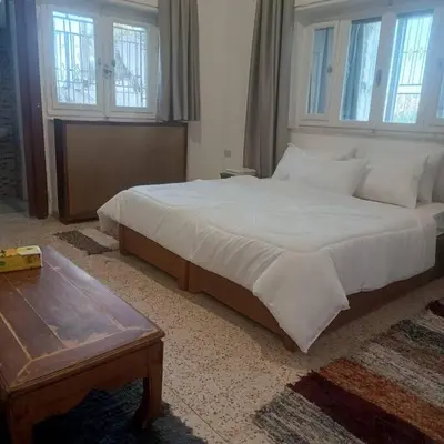 a bedroom with a large bed and a wooden table at B Beitna in Amman