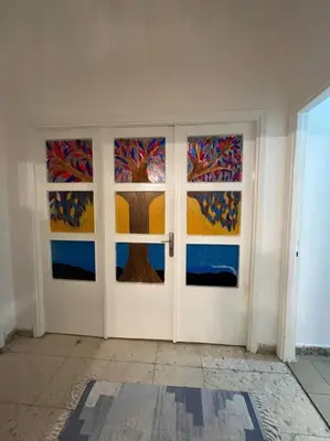 a room with two doors with a tree painted on them at B Beitna in Amman
