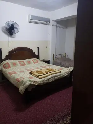 a bedroom with a bed and a fan on the wall at ALOTAIBI bulding # 6 in Amman