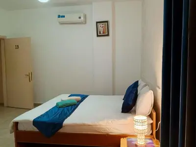 a small bedroom with a bed with blue pillows at Jordan River hotel in Amman