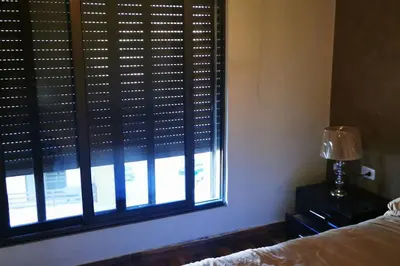 a bedroom with a window with a bed and a lamp at Apartment in Amman 7'th Circle in Amman