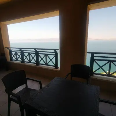 a table and chairs in a room with a view of the ocean at E23 Luxury - Full Sea view-Samra Resort in Sowayma