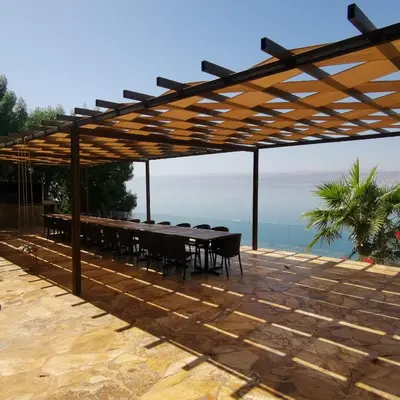 a wooden pergola with a table and chairs at E23 Luxury - Full Sea view-Samra Resort in Sowayma