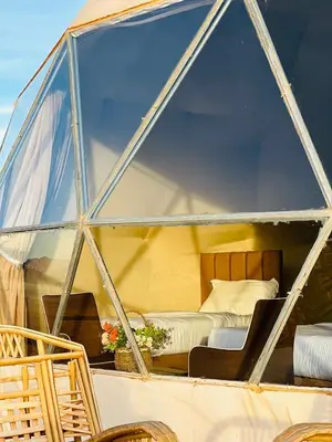 a view of a bed in a glass house on a boat at Camille WadiRum Camp in Disah