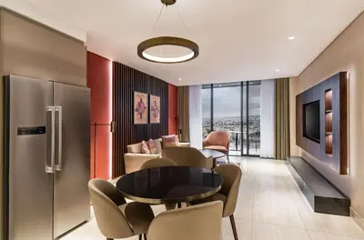 a living room with a table and chairs at Doubletree By Hilton Amman Hotel & Residences in Amman