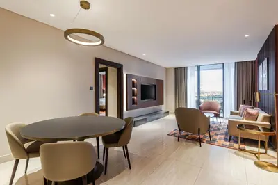 a living room with a dining room table and chairs at Doubletree By Hilton Amman Hotel & Residences in Amman