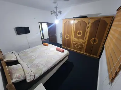 a bedroom with a bed and a wooden cabinet at Artemis Hotel in Jerash