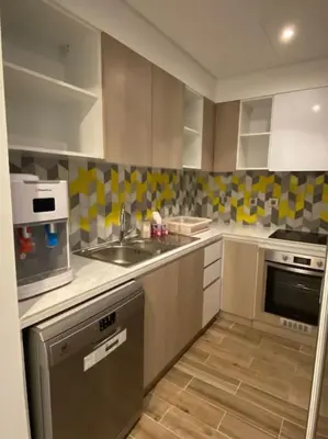 a kitchen with a sink and a microwave at Lovely 2-Bedroom with pool in the heart of Aqaba in Aqaba
