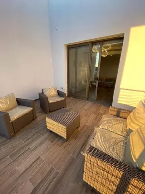 a living room with a couch and chairs in a room at Lovely 2-Bedroom with pool in the heart of Aqaba in Aqaba