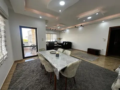 a living room with a table and chairs at 8-New and Spacious Apartments Close to Market in Amman
