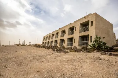 a building in the middle of a dirt field at Azraq Lodge in Al Azraq ash Shamālī