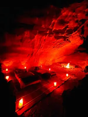 a cave with candles and beds in the dark at Emad wadi rum camp in Wadi Rum
