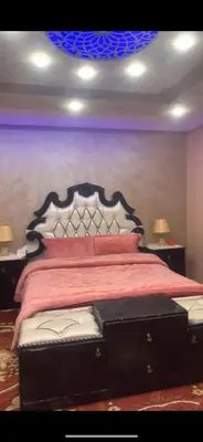a bedroom with a large bed with a red bedspread at Jordan in Irbid