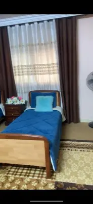 a bedroom with a bed with a blue blanket and a window at Jordan in Irbid