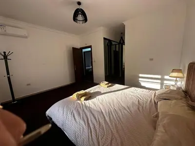 a bedroom with a bed with two towels on it at 5-New and Spacious Apartments Close to Market in Rujm ash Sharāʼirah