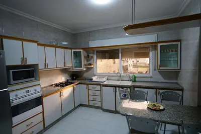 a kitchen with white cabinets and a counter top at Modern Flat in Heart of Amman in Amman
