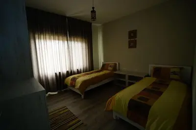 a hotel room with two beds and a window at Modern Flat in Heart of Amman in Amman
