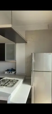 a kitchen with a white stove and a white refrigerator at Omar in Al Bunayyāt ash Shamālīyah