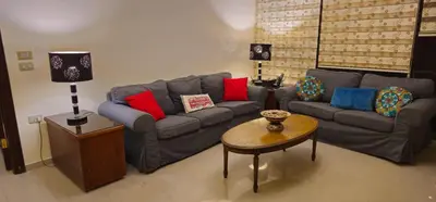a living room with a couch and a table at Luxuries Furnished Apartment in Shmeisani in Amman