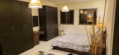 a bedroom with black cabinets and a bed and a sink at Luxuries Furnished Apartment in Shmeisani in Amman