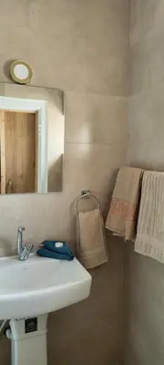 a bathroom with a sink and a mirror and towels at Blue Stone H in Madaba
