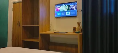 a bedroom with a tv on the wall and a bed at Blue Stone H in Madaba