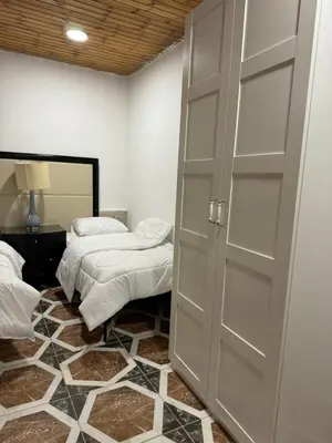 a room with two beds and a sliding door at Golden Horse Chalet And Club in Maḩaţţat al Jīzah