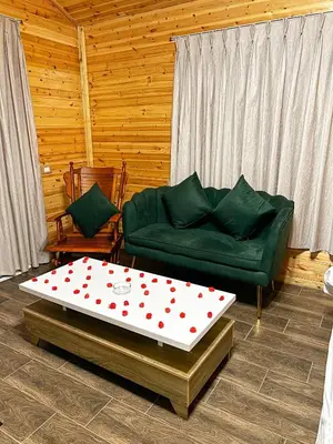a living room with a green couch and a coffee table at اكواخ سفاري السياحية in Ajloun