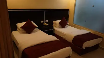 a hotel room with two beds and a window at فندق ملتقى البتراء in Wadi Musa