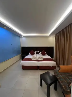 a hotel room with a bed and a couch at فندق ملتقى البتراء in Wadi Musa