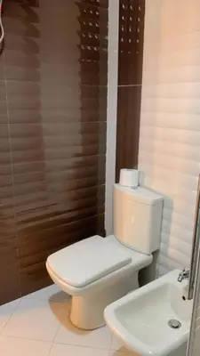 a bathroom with a white toilet and a sink at Rooftop View in Amman