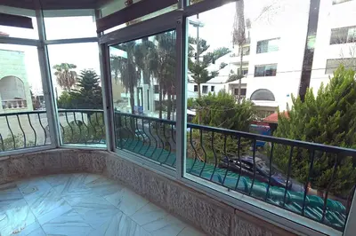 a balcony with windows and a view of a street at Fully Equipped 3BR Apt in Family-Friendly Building in Amman
